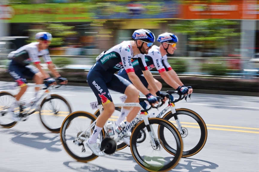 男人骑着自行车在路上行驶描述已自动生成